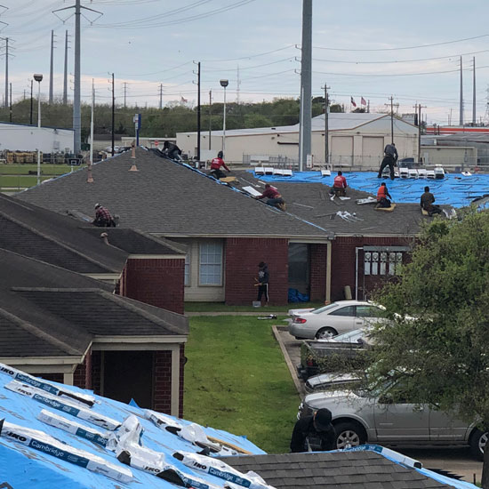 workers putting new roof on commercial building